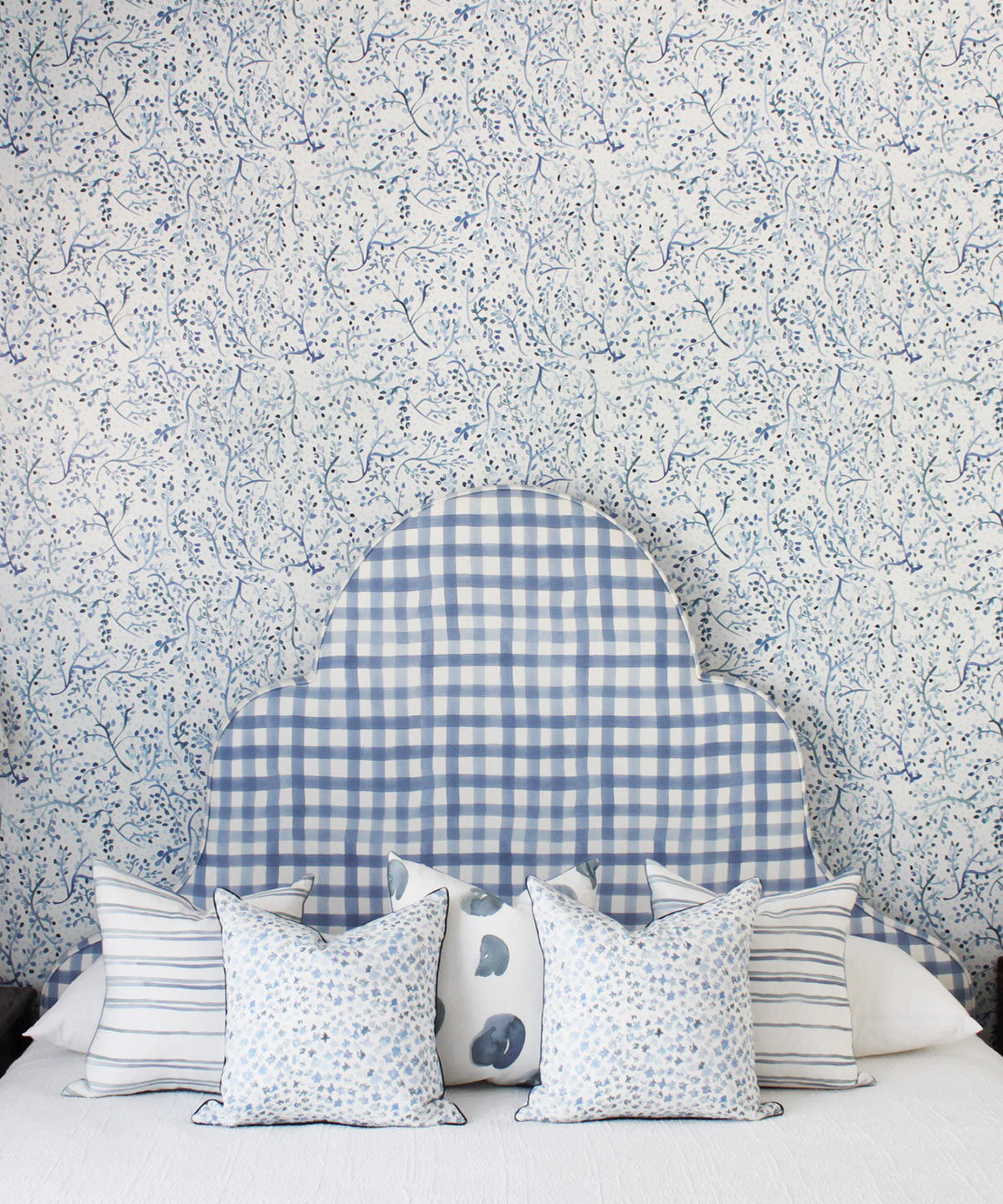Indigo Garden • Blue Botanical Wallpaper • Floral • Bedroom with plaid blue headboard and white pillows. Milton & King Europe